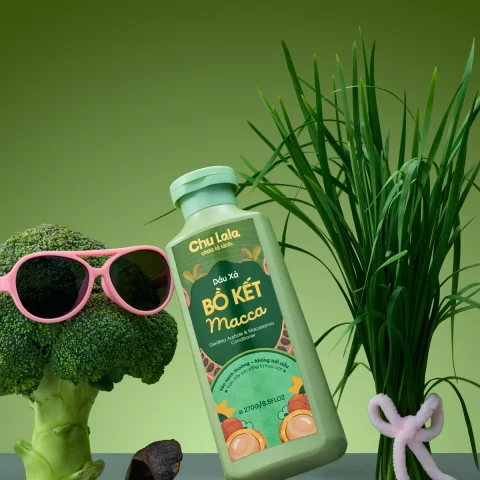 Chai dầu xả Chu Lala Bồ Kết Macca bên cây bông cải đeo kính râm và hạt mắc ca
