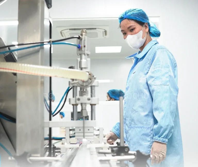 Nhân viên mặc đồ bảo hộ vận hành máy chiết rót trong xưởng của nhà máy ROCHU